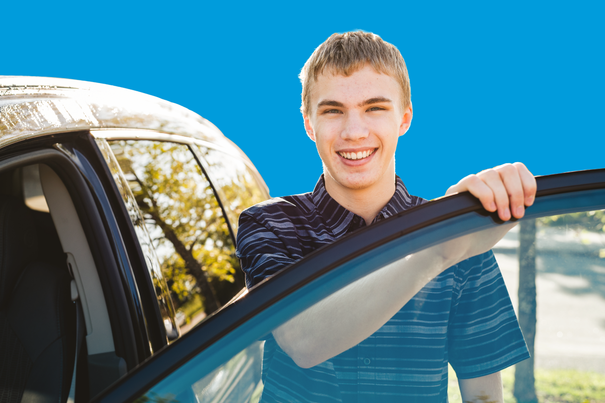 Student driver standing outside of a car