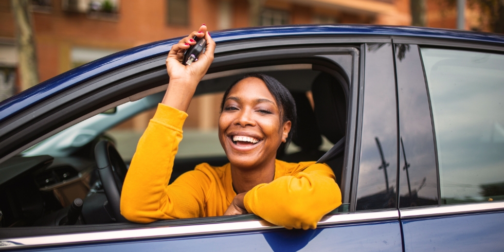 A woman sitting in her new car